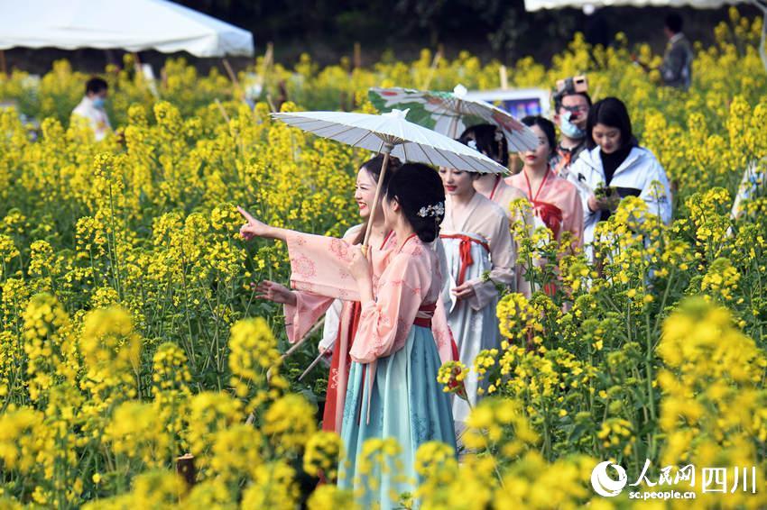 游客身穿漢服在油菜花田里嬉戲、拍照。蔣永平攝