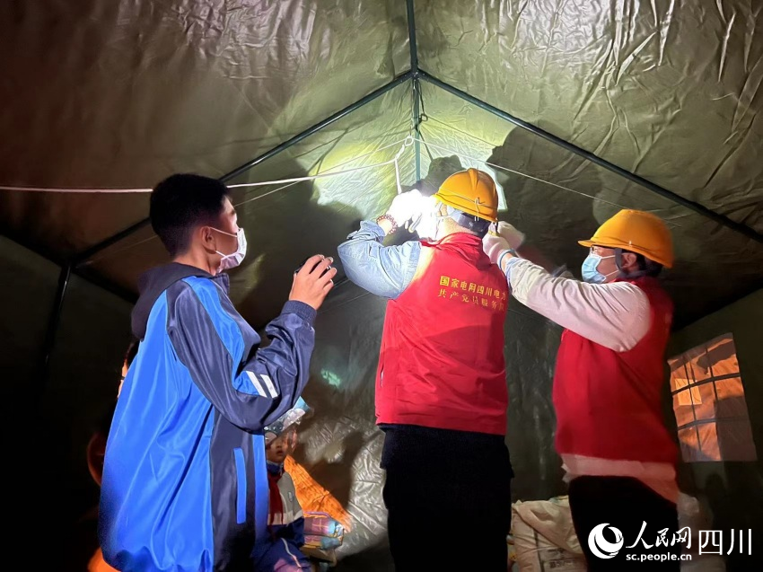 小朋友幫助電力工人照明。湯衛攝