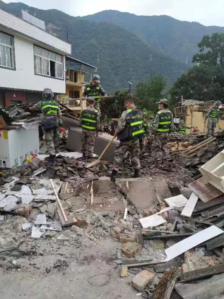 民兵在廢墟中開展搜救。四川省軍區(qū)供圖