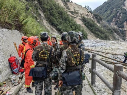 退役軍人志愿者與專業救援隊伍一起進溝開展救援工作，協助消防救援人員搭建救援便橋。四川省退役軍人事務廳供圖