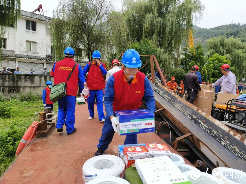 圖為曹浩和隊員們正將應急物資搬運上沖鋒舟。廖亮攝