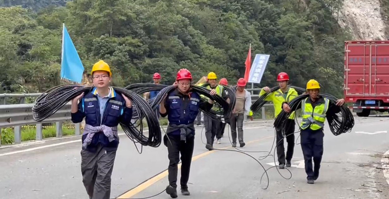 四川移動(dòng)樂山分公司黨員突擊隊(duì)負(fù)重徒步前往災(zāi)區(qū)指定地域。四川省國資委供圖