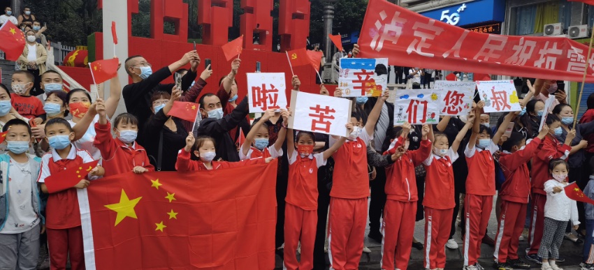 9月13日，瀘定縣，當?shù)鼐用衽e著條幅送別救援隊伍。程雪力攝