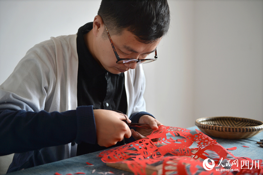 李有生在創(chuàng)作剪紙。王斌攝