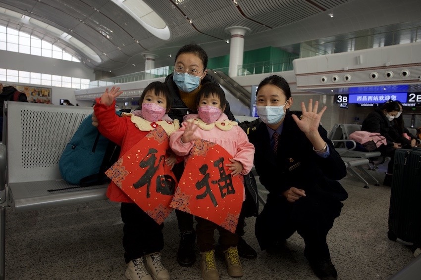 在沿途站點，車站工作人員為旅客送上“福”字及新春禮物。成都鐵路供圖