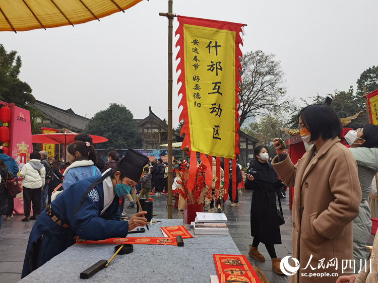 在什邡互動區，為市民寫春聯。人民網 王波攝
