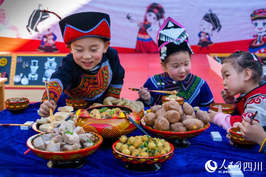 彝族年被稱為“嘴巴的節(jié)日”，圖為幼兒園內(nèi)的小朋友們在品嘗彝族傳統(tǒng)美食。范艷民攝