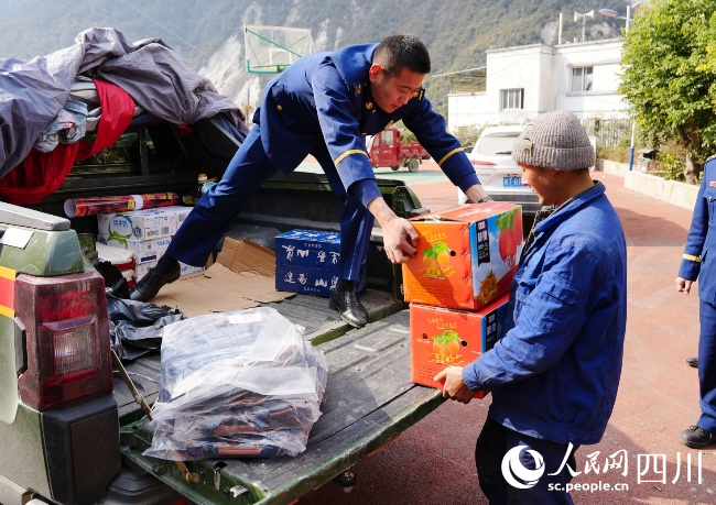 1月17日，在雅安市石棉縣王崗坪彝族藏族鄉愛國村，消防救援人員為群眾送去慰問品。李從林攝