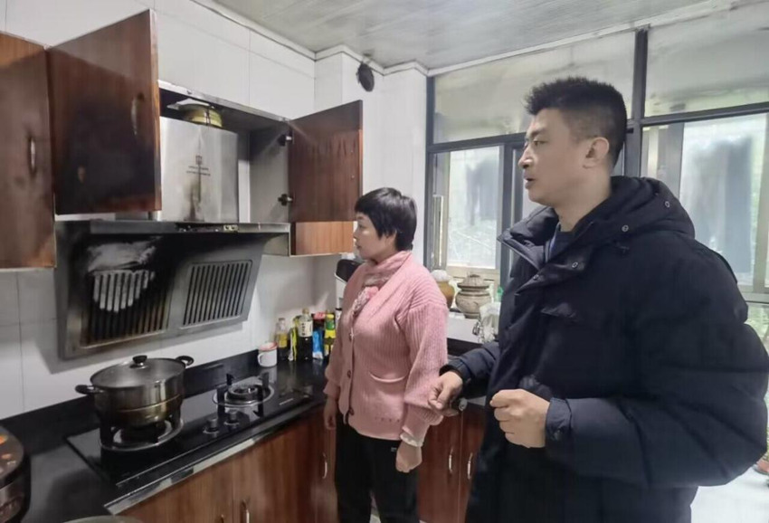黃勇向吳阿姨講解安全用火用電常識。四川煙草供圖