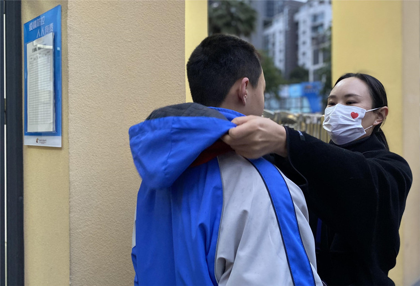 新學期老師在為剛入校的同學整理衣服。成都市青羊實驗中學供圖