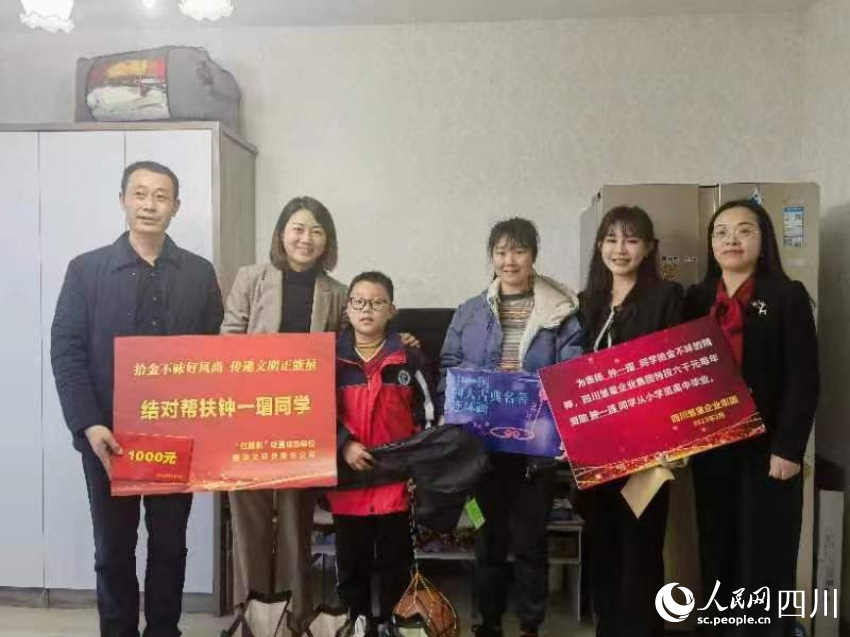 圖為愛心人士為鐘一瑁送去助學“大禮包”。劉佳雨攝