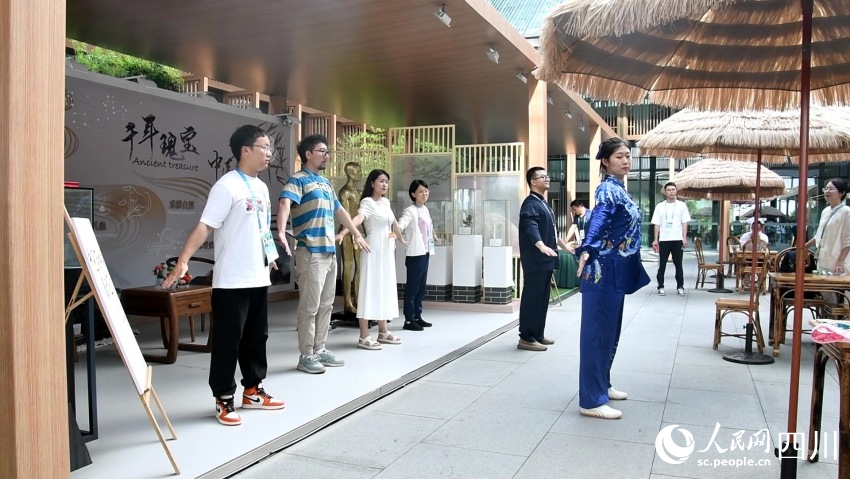 展示區工作人員正在帶領參觀者體驗八段錦。人民網記者 王洪江攝