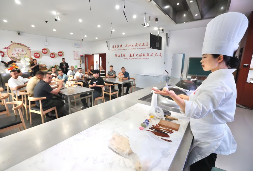 成都市國家通用語言文字教育教學培訓基地內(nèi)，面點老師正在為學員講解面點制作技巧。王磊供圖