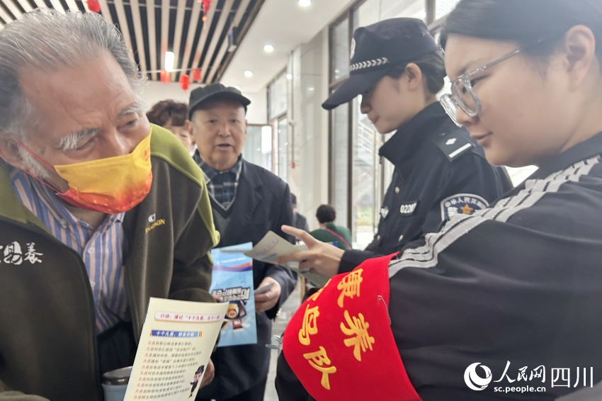 “康養候鳥隊”隊員為老人送上反詐宣傳資料。人民網記者 李平攝