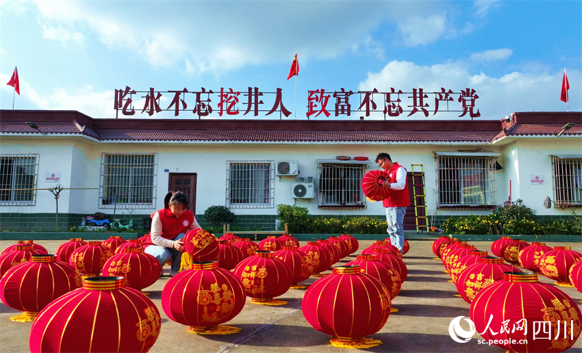 黨員志愿者正在整理送給群眾的燈籠。潘建勇攝