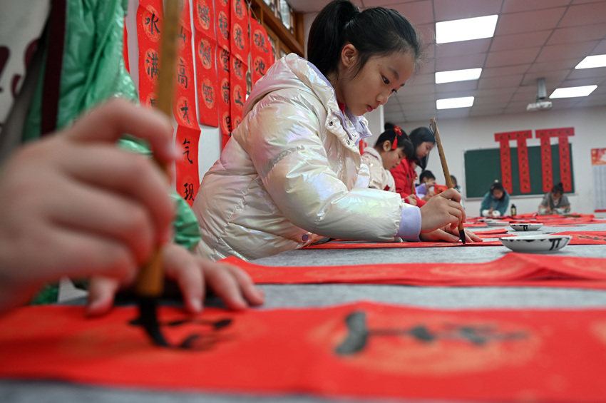 為社區(qū)居民書寫春聯(lián)和“福”字。蘭自濤攝