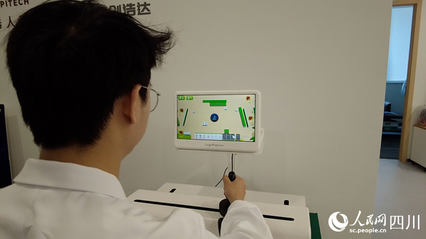 工作人員正在演示上肢康復機器人。人民網(wǎng)記者 郝帥攝