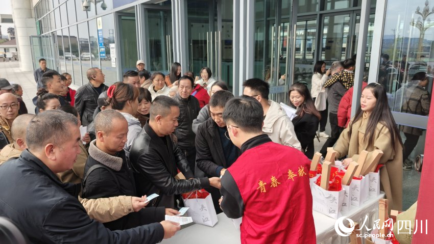 乘坐夾江站首發(fā)列車的旅客領取宣傳品。陳萱攝