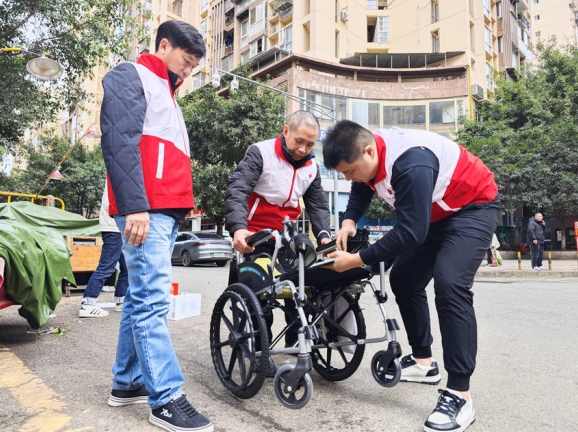 喻學建和志愿者為老人送來新輪椅。成都小義愛心公益服務(wù)中心供圖