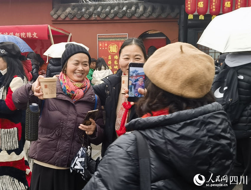 市民拍照展示領(lǐng)取到的臘八粥。實習(xí)生 馮子芯攝