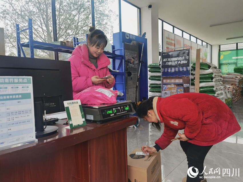 騎龍村金通快遞驛站，農(nóng)戶正在簽收網(wǎng)購(gòu)的物品，農(nóng)村路的通暢也助力了工業(yè)品的下行。人民網(wǎng)記者 郭瑩攝