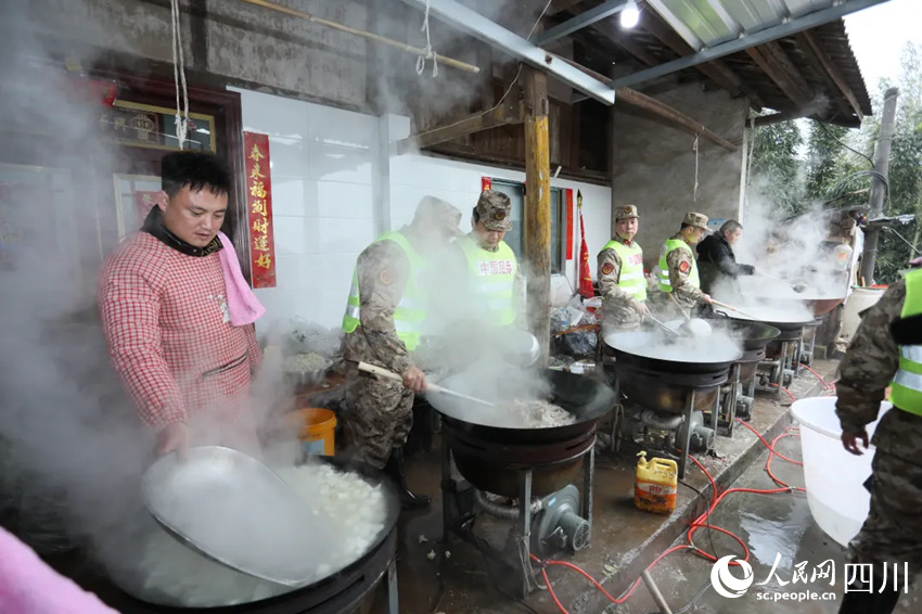 “臨時(shí)廚房”里，救援隊(duì)伍與村民一同制作飯菜。鄭鵬攝