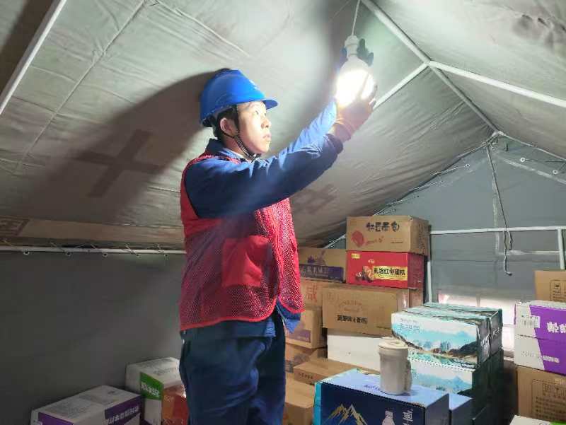 在受災群眾安置點，國網宜賓供電公司搶險支援人員第一時間為紅十字會救災帳篷安裝照明燈。楊義偉攝