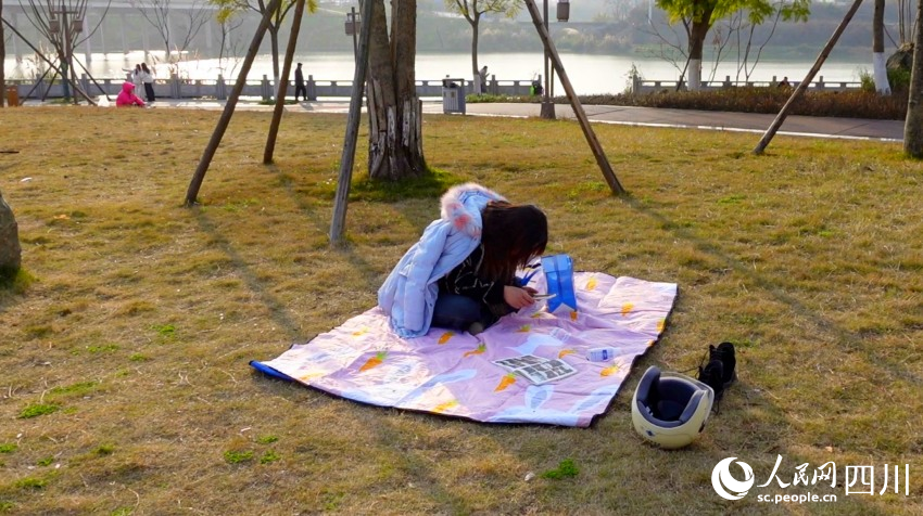 市民在花萼濕地公園草坪曬太陽。鐘欣航攝