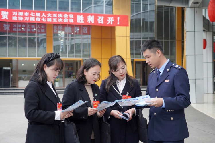 稅務干部向萬源“兩會”代表宣傳稅費政策。萬源市稅務局供圖