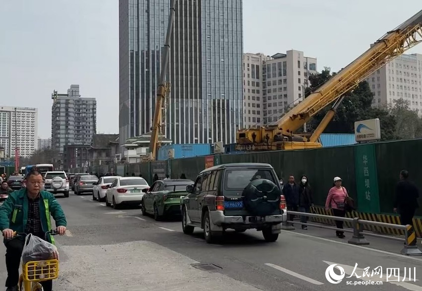 道路一側(cè)，地鐵建設(shè)穩(wěn)步推進(jìn)，一邊，車流人流有序通行，建設(shè)單位加緊施工邊雨進(jìn)一步釋放通行道路。人民網(wǎng)記者 郭瑩攝