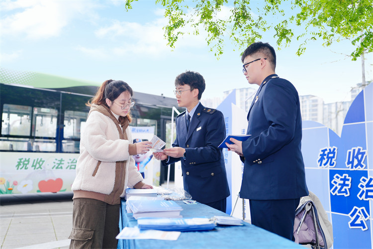 稅務干部在公交車站為納稅人講解稅收政策。成都市稅務局供圖