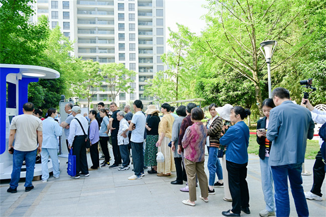 社區居民排隊等待體驗沉浸式膠囊診所智慧醫療。四川省第四人民醫院供圖