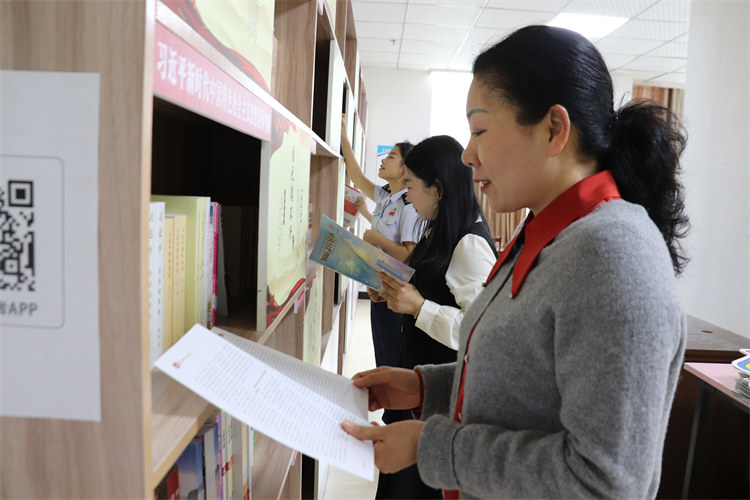 稅務干部和社區工作人員在共享圖書館一起閱讀稅務讀本。達州市稅務局供圖
