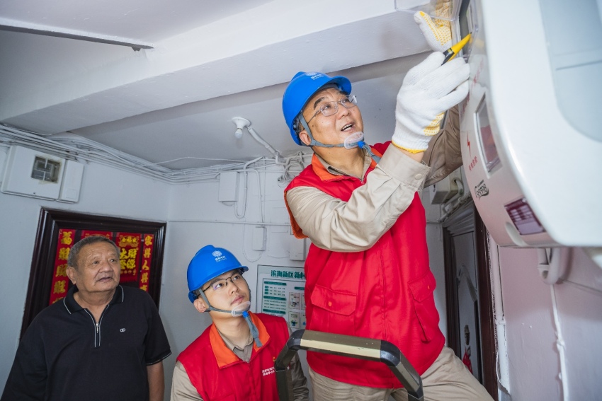 張黎明（右）帶領國家電網天津電力心連心（濱海黎明）共產黨員服務隊到濱海新區丹東里小區為居民查看電表，解決百姓用電問題。國網天津濱海供電公司供圖