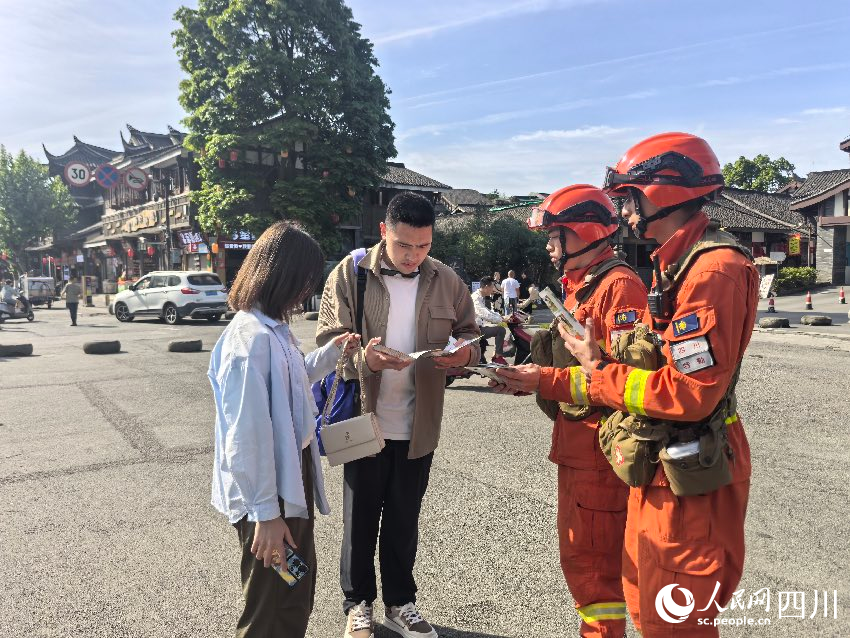 5月1日，都江堰景區，消防員唐平、譚弋飛正在進行防火宣傳。程雪力攝