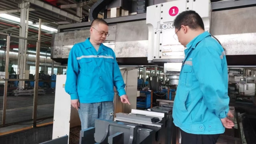 劉斌（左）和團隊人員一同檢查刀具的端面跳動和磨損情況。李若菡攝