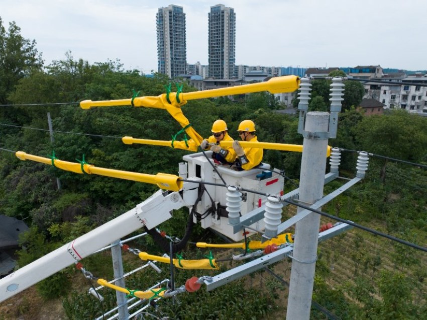 2024年6月14日，國網綿陽供電公司在10千伏回九線開展帶電接引流線施工作業，確保高溫天氣下周邊居民用電不受影響。田海攝