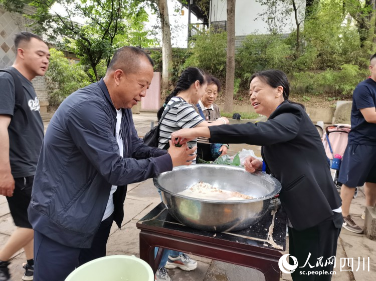 工作人員正在指導游客包粽子。李建生攝