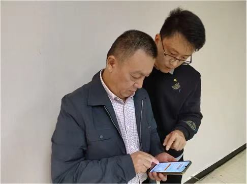 黃太平指導(dǎo)零售客戶線上訂貨。內(nèi)江市煙草專賣局東興區(qū)局（分公司）供圖