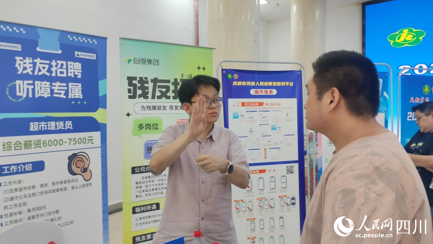 自強集團招聘專員用手語與應聘殘友溝通。施瑩攝