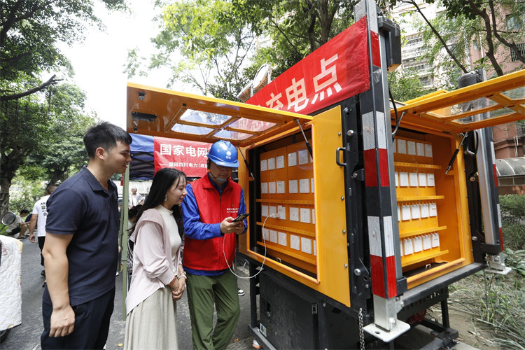 7月4日，在成華區銀鑼灣小區，國網成都供電公司成華供電中心設置應急充電點，共產黨員服務隊隊員為居民提供現場充電服務。陳紅梅攝