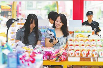 7月14日，游客在官方特許商品零售店紅星路店挑選世運(yùn)會(huì)周邊商品。