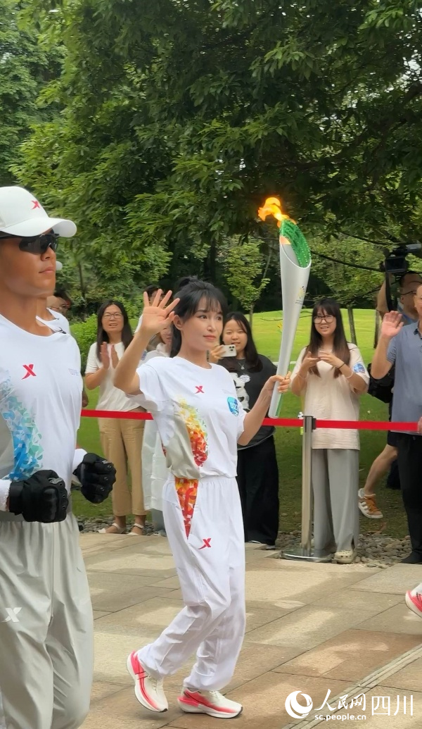 李子柒一邊傳遞一邊向場邊揮手。成都世運會執委會供圖
