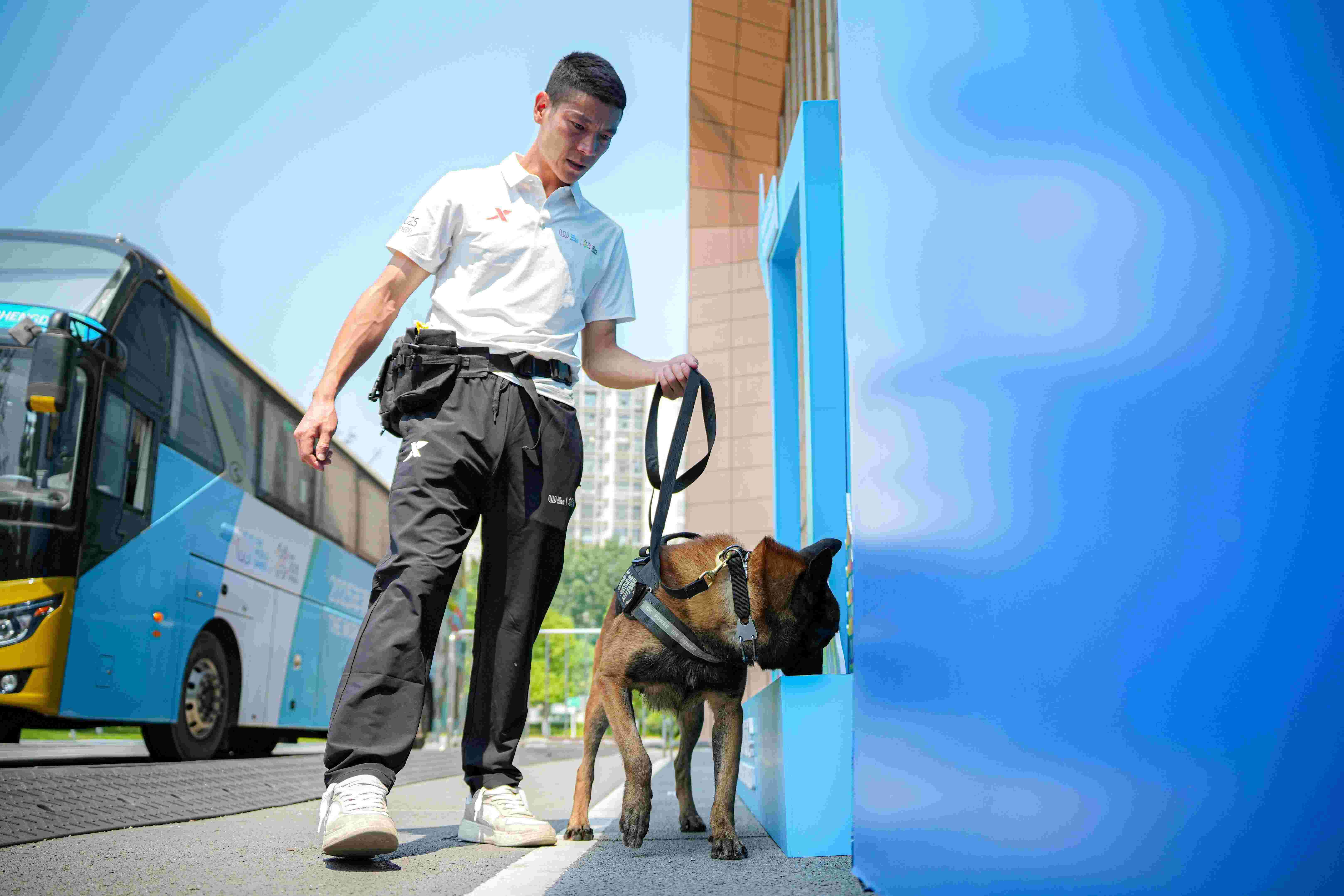 訓犬員韓學軍與搜爆犬黑龍對場館外進行安檢。新都公安供圖