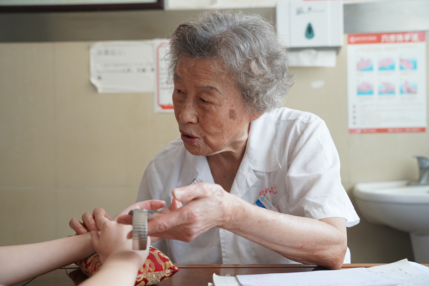 李恒明為病人把脈。屈超英攝