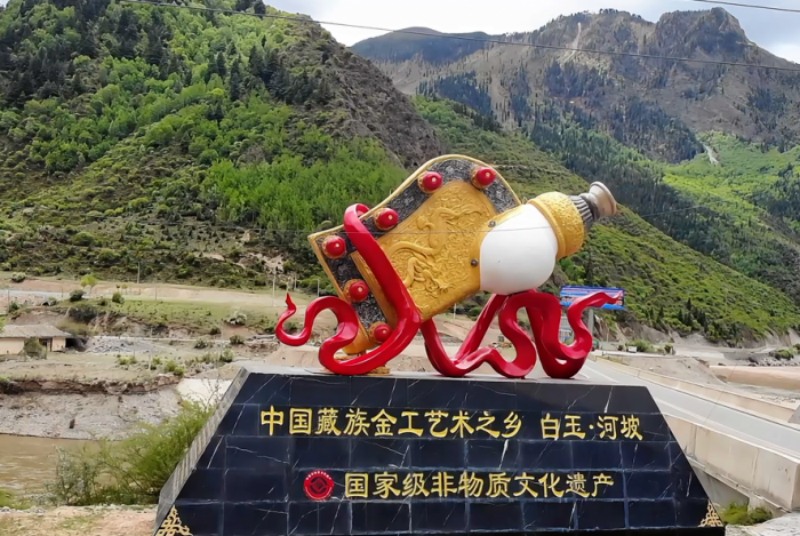 位于河坡鎮的“中國藏族金工藝術之鄉”雕塑。白玉縣委宣傳部供圖